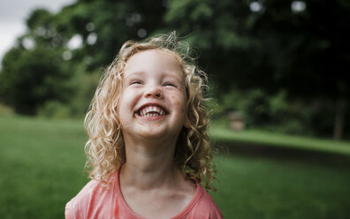 Cute cheerful girl looking away at park - CAVF60848