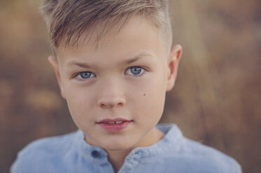 Portrait of boy with blue eyes on field - CAVF60883