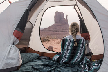 Rear view of woman with scarf sitting in tent at Monument Valley Tribal Park - CAVF60912
