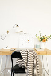 Technologien mit Kalender und Schreibtischlampe neben Blumenvase auf Tisch im Büro - CAVF60957