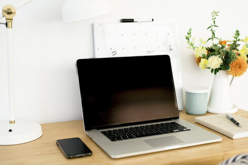 Hohe Winkel Ansicht von Technologien mit Kalender und Schreibtischlampe von Blumenvase auf Holztisch im Büro - CAVF60959