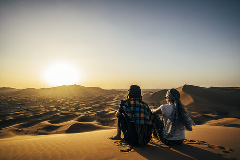 Ein Paar genießt die sonnige Aussicht auf eine abgelegene Sandwüste, Sahara, Marokko - CAIF22618