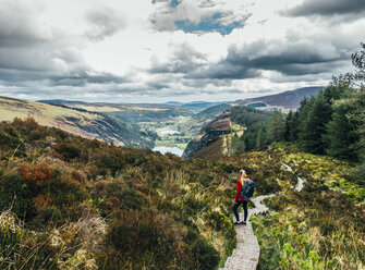 Frau beim Wandern auf einem idyllischen Bergpfad mit Blick auf eine malerische Landschaft, Wicklow NP, Irland - CAIF22621