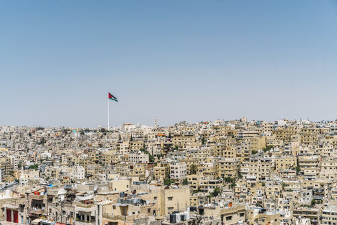 Die jordanische Flagge weht über den sonnigen Gebäuden der Stadt, Amman, Jordanien - CAIF22633