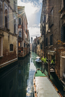 Die Sonne scheint über ruhige Gebäude und einen Kanal mit Gondeln, Venedig, Italien - CAIF22635