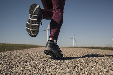 Junge Frau beim Joggen auf dem Feldweg, Windräder im Hintergrund - SEBF00002