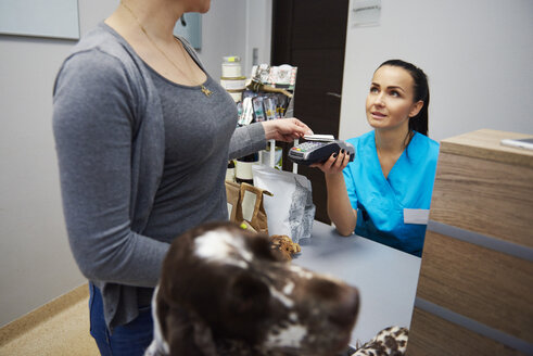 Hundehalter zahlt mit Kreditkarte in Tierarztpraxis - ABIF01233