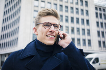 Portrait of smiling young man talking on cell phone in the city - MOEF02130