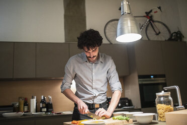 Mann schneidet Gemüse, kocht Abendessen in der Wohnküche - CAIF22659