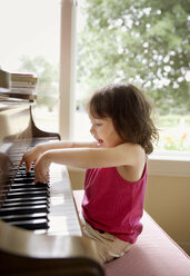 Happy baby girl playing with piano at home - CAVF61052