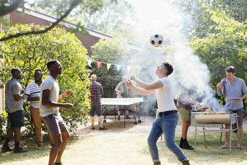 Männliche Freunde spielen Fußball und Tischtennis, genießen das Grillen im Hinterhof - CAIF22750
