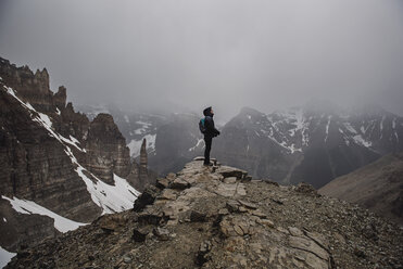 Wanderin auf dem Gipfel eines zerklüfteten, nebligen Berges in Banff, Alberta, Kanada - CAIF22773