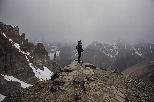 Wanderin auf dem Gipfel eines zerklüfteten, nebligen Berges in Banff, Alberta, Kanada - CAIF22773