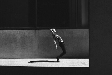 Junger Mann tanzt auf städtischem Bürgersteig - CAIF22774