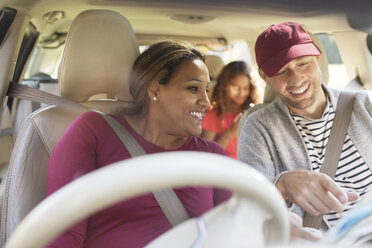 Couple on road trip, looking at map in car - CAIF22789