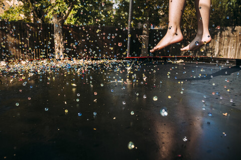 Niedriger Ausschnitt eines auf einem Trampolin springenden Mädchens an einem sonnigen Tag, lizenzfreies Stockfoto
