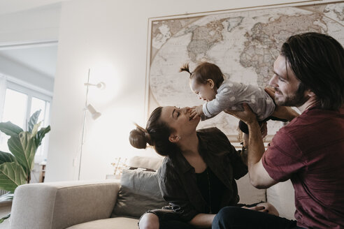 Happy family playing with baby girl in living room at home - LHPF00450