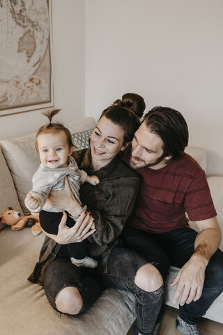 Glückliche Familie mit Baby-Mädchen im Wohnzimmer zu Hause, lizenzfreies Stockfoto