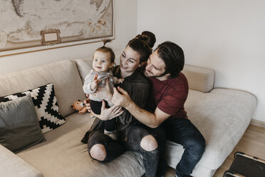 Glückliche Familie mit Baby-Mädchen im Wohnzimmer zu Hause - LHPF00452