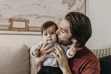 Glücklicher Vater küsst Baby Mädchen im Wohnzimmer zu Hause - LHPF00456