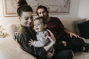 Glückliche Familie mit Baby-Mädchen im Wohnzimmer zu Hause - LHPF00457