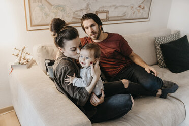 Happy family with baby girl in living room at home - LHPF00458