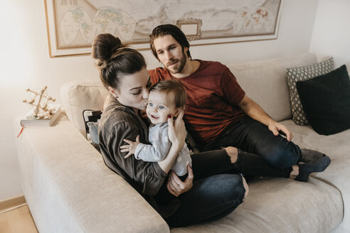 Glückliche Familie mit Baby-Mädchen im Wohnzimmer zu Hause - LHPF00458