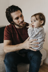 Father holding baby girl at home - LHPF00460