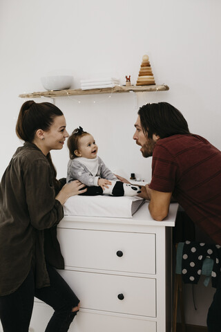 Familie mit kleinem Mädchen im Babyzimmer zu Hause, lizenzfreies Stockfoto