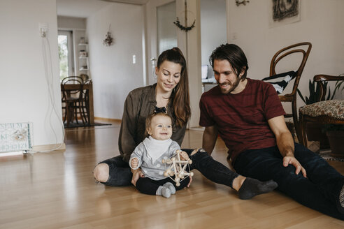 Glückliche Familie mit einem kleinen Mädchen, das zu Hause auf dem Boden sitzt - LHPF00479