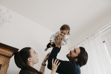 Glückliche Familie spielt mit dem kleinen Mädchen zu Hause - LHPF00485