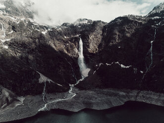 Landschaftlicher Blick auf einen Wasserfall inmitten von Bergen bei bewölktem Himmel im Winter - CAVF61242