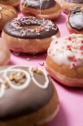 Hohe Winkel Ansicht der verschiedenen Donuts auf rosa Hintergrund angeordnet - CAVF61301