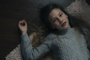 High angle portrait of girl lying on rug at home - CAVF61316