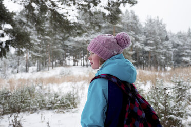 Seitenansicht einer Frau mit Rucksack im schneebedeckten Wald - CAVF61340