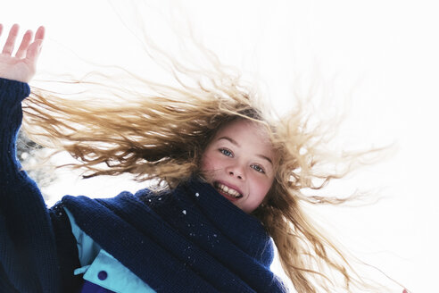 Low angle portrait of happy woman with blond hair standing against clear sky during winter - CAVF61346