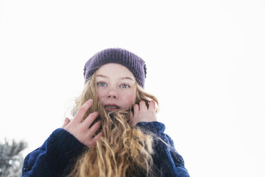 Low angle portrait of woman with blond hair standing against clear sky during winter - CAVF61347