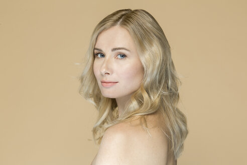 Porträt einer nackten blonden Frau vor einem beigen Hintergrund - VGF00223