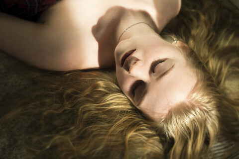 High angle view of woman with blond hair sleeping on bed at home stock photo