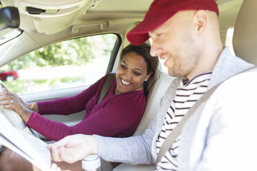 Ehepaar betrachtet Karte im Auto auf einer Autoreise - CAIF22800