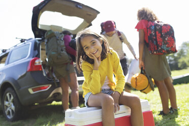 Portrait smiling girl camping with family, unloading car - CAIF22811