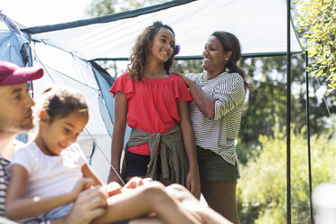 Zärtliche Mutter bürstet ihrer Tochter auf dem Campingplatz die Haare - CAIF22832