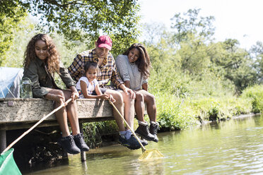 Glückliche Familie beim Angeln vom sonnigen Bootssteg aus - CAIF22850