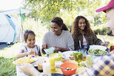 Glückliche Familie genießt das Mittagessen am Campingtisch - CAIF22851