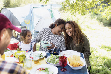 Affectionate, happy family enjoying lunch at campsite table - CAIF22859
