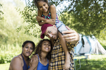 Glückliche, liebevolle Familie macht Selfie mit Fotohandy auf dem Campingplatz - CAIF22862