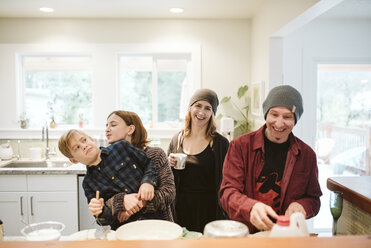 Porträt einer fröhlichen, verspielten Familie beim Backen in der Küche - CAIF22870