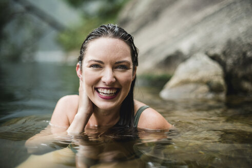 Porträt lächelnd, schöne junge Frau schwimmt im See - CAIF22877
