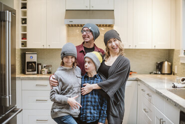 Porträt einer dummen Familie, die in der Küche Grimassen schneidet - CAIF22883