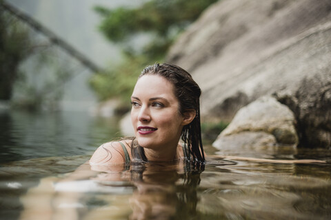 Lächelnde schöne Frau beim Schwimmen im See, lizenzfreies Stockfoto